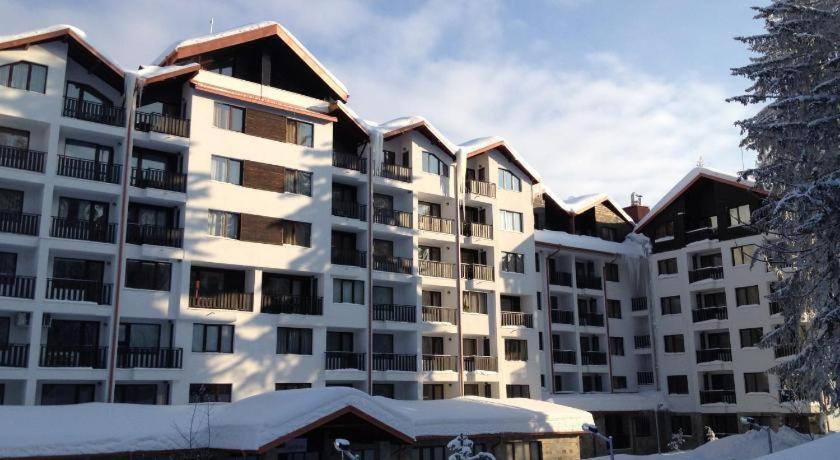 a large apartment building with snow on the ground at Borovets Gardens Apartments TMF in Borovets