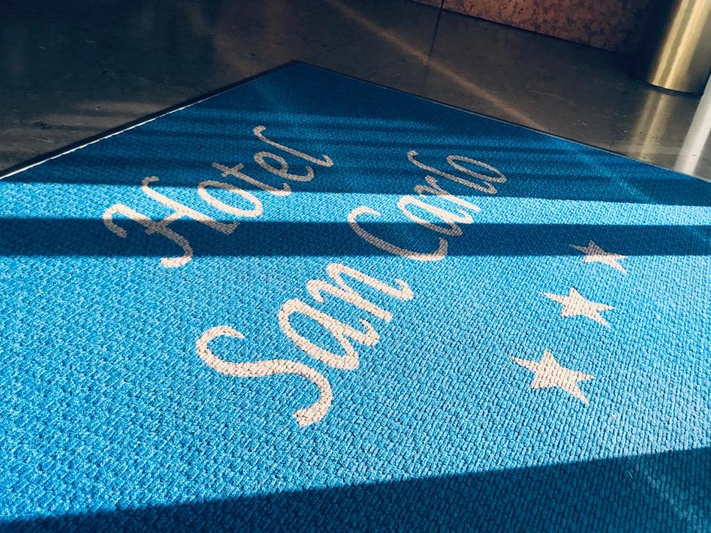 梅斯特的住宿－聖卡羅酒店，上面写着出售字的蓝色地毯