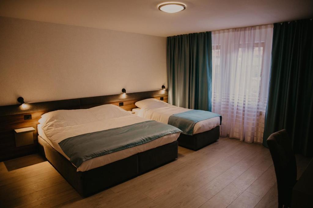 a hotel room with two beds and a window at Saray&App in Sarajevo