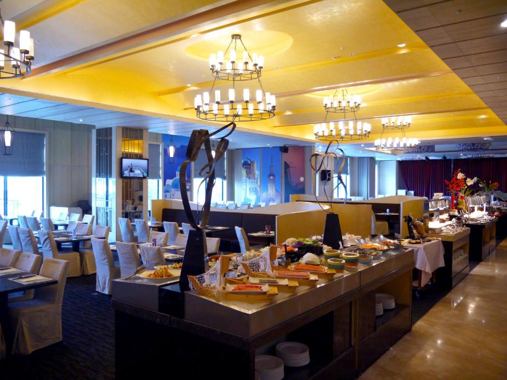 a dining room with tables and chairs and chandeliers at Fullon Hotel Tamsui Fishermen&#39;s Wharf in Tamsui
