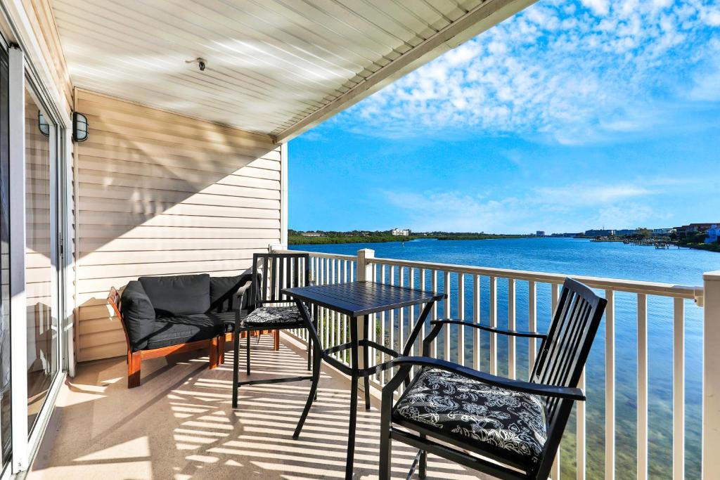 a balcony with a table and chairs and the water at Captain Coves #102 in Clearwater Beach