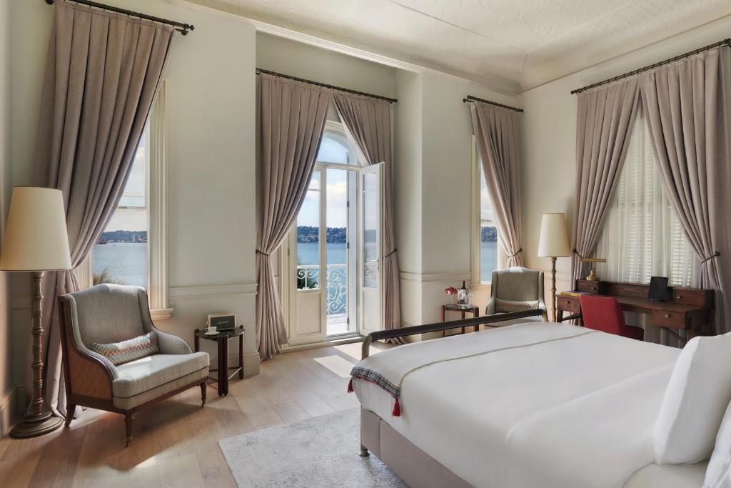 a bedroom with a bed and a chair and windows at Six Senses Kocatas Mansions in Istanbul