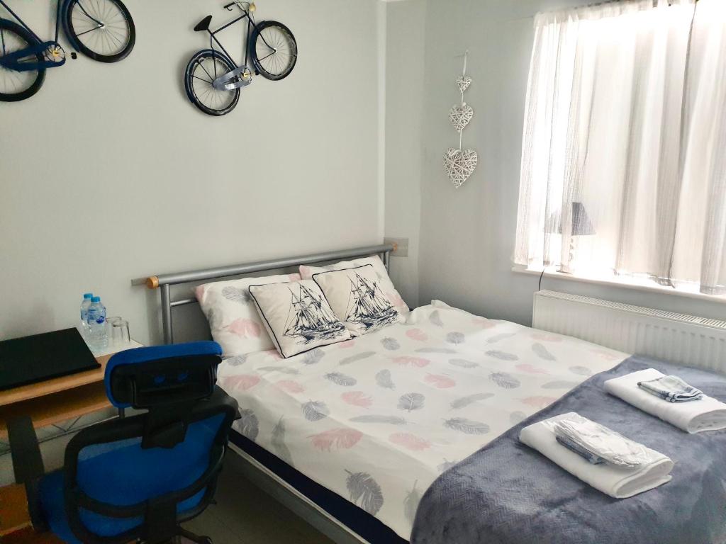 a bedroom with a bed and a desk with a bike on the wall at Comfortable rooms in the house in Oxford