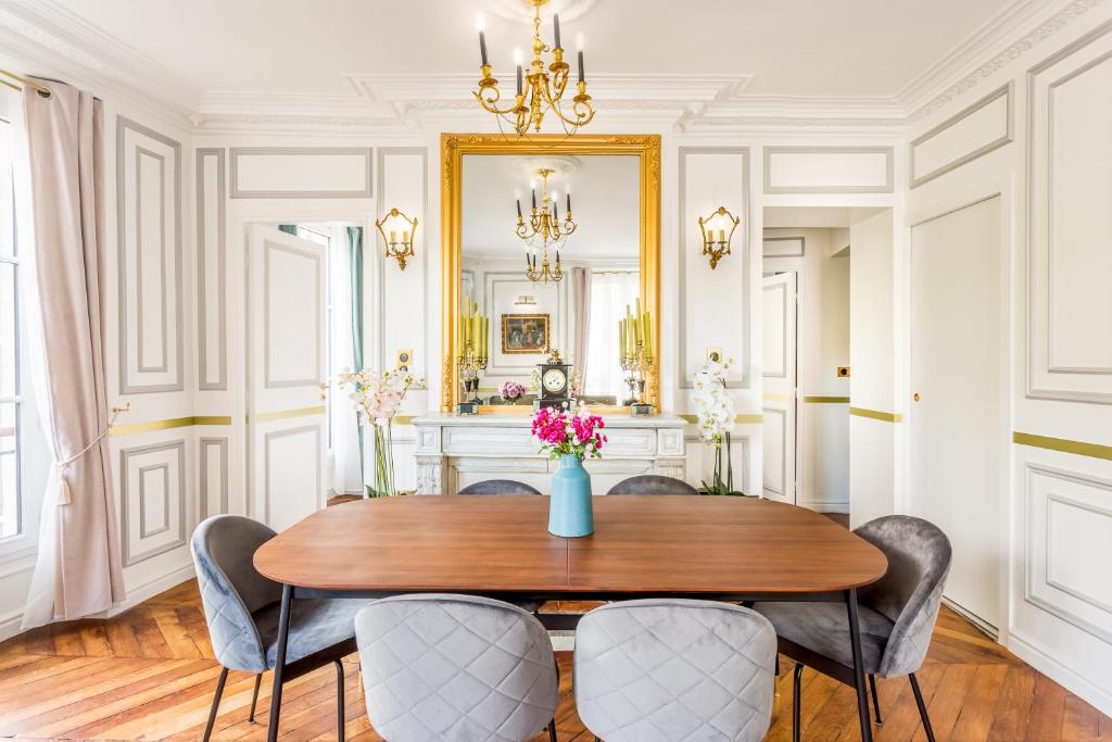 a dining room with a table and chairs and a mirror at Luxury 2 Bedroom With Balcony - Louvre & Notre Dame in Paris