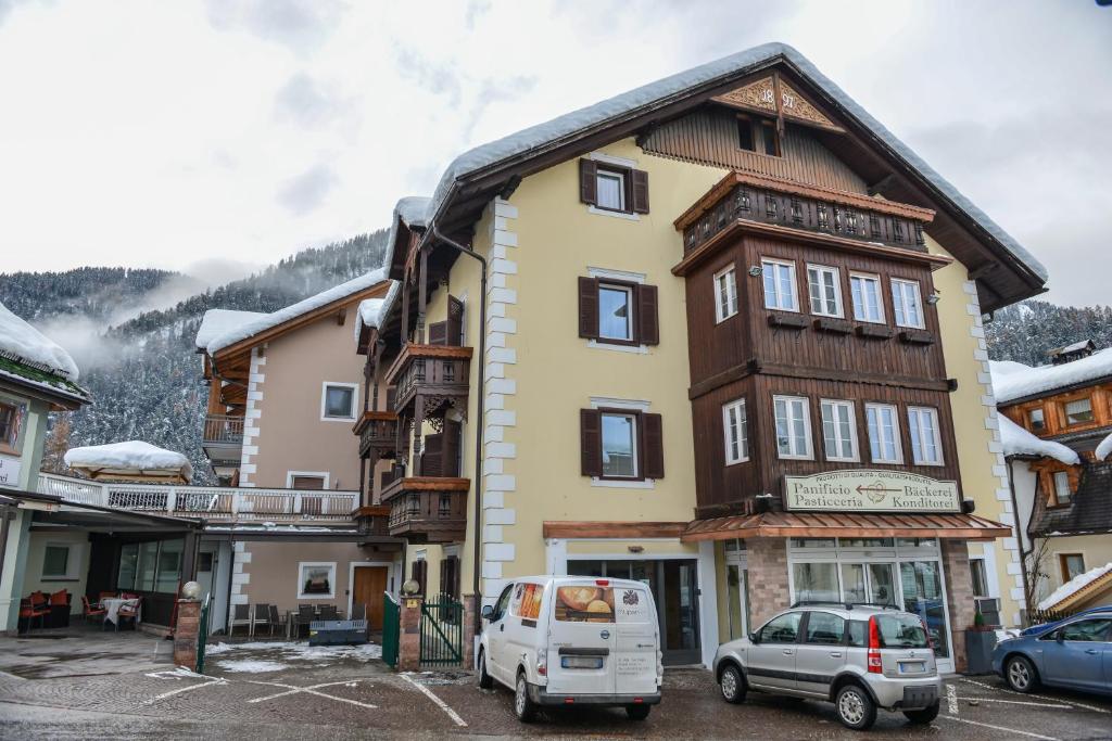 un edificio con una furgoneta estacionada frente a él en Apartments Mupan, en San Vigilio Di Marebbe