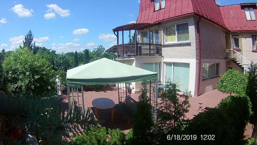 uma casa grande com um guarda-chuva verde em frente em Family em Kaunas