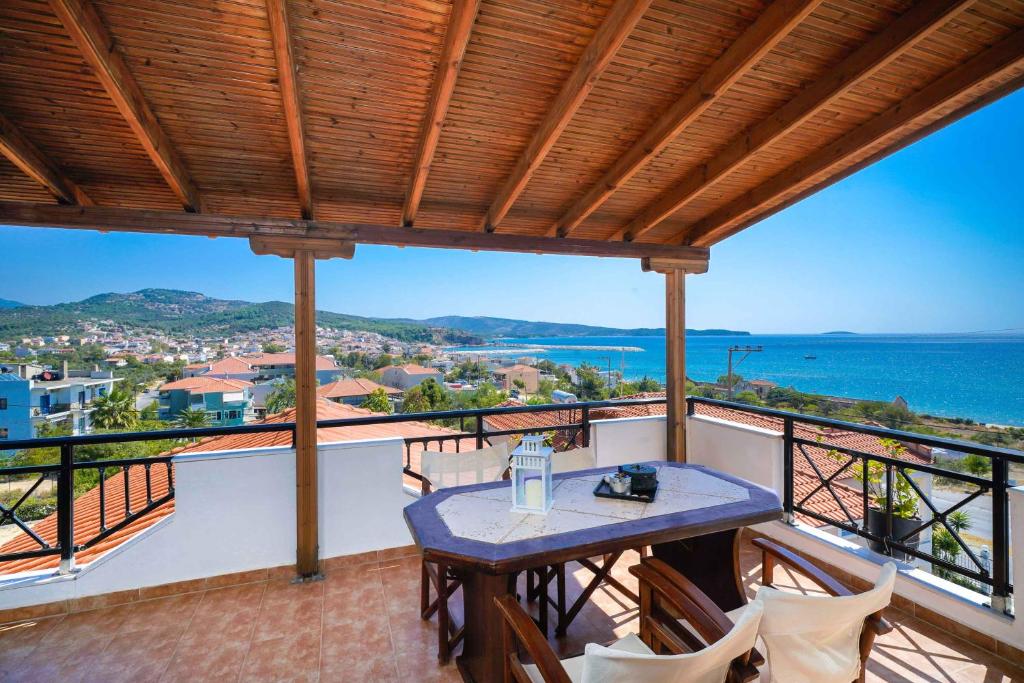 d'un balcon avec une table et des chaises donnant sur l'océan. dans l'établissement Villa Golden Nest, à Limenaria