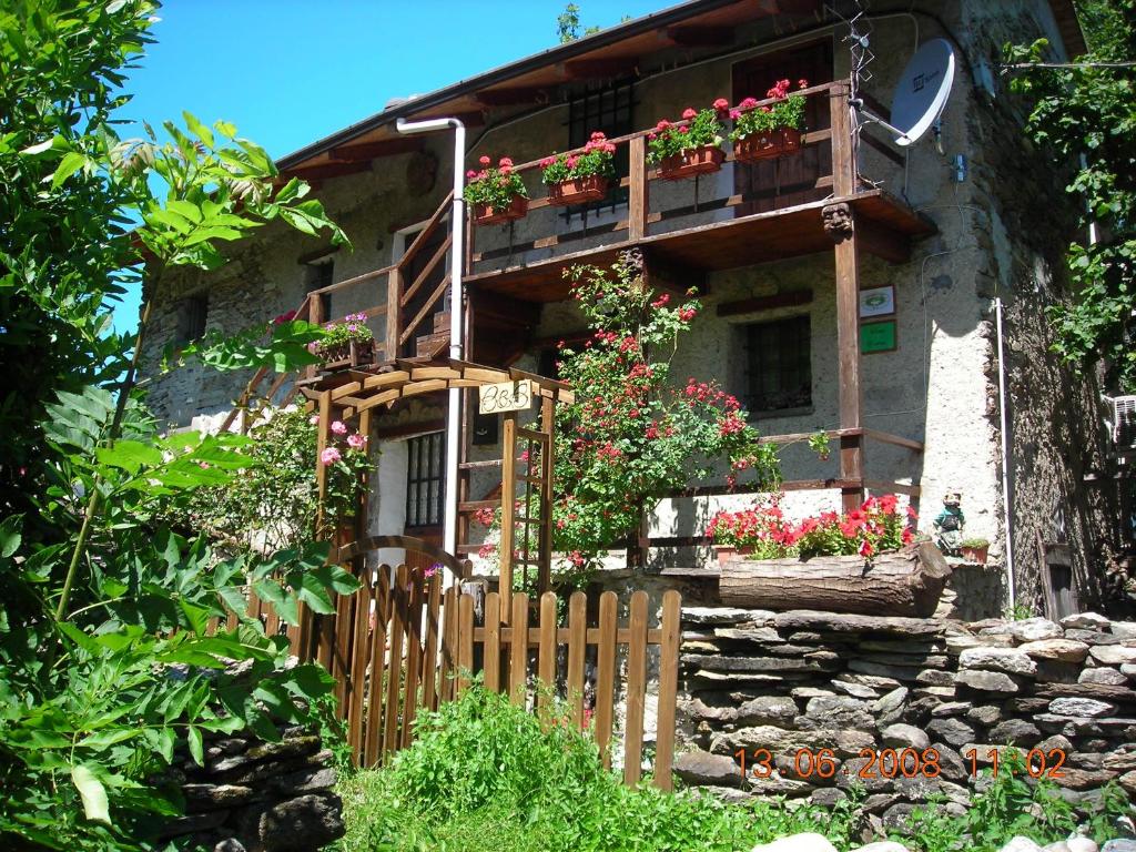 a house with flower boxes on the front of it at B&B Baita Evelina in San Giorio