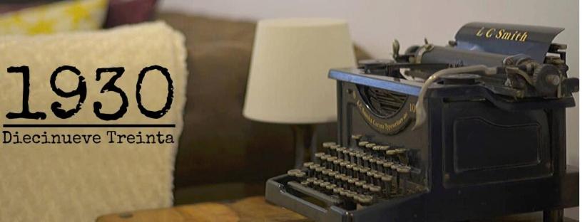 una macchina da scrivere vecchia maniera seduta accanto a un cartello di 1930. DIECINUEVE TREINTA a Gijón