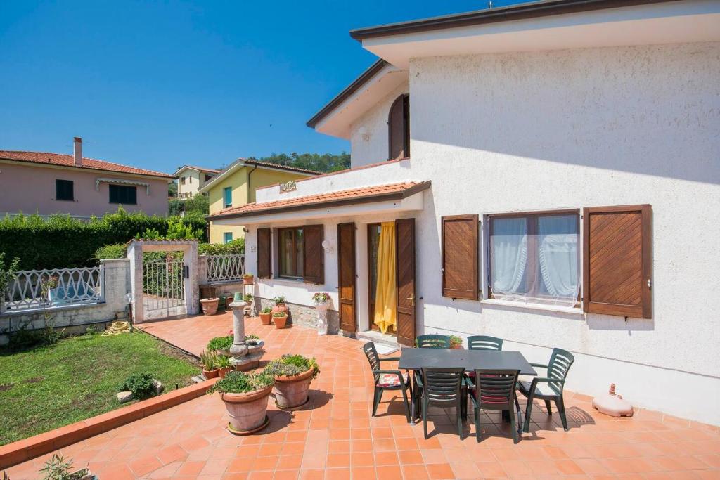 a patio with a table and chairs in front of a house at ALTIDO Villa for 4 with Garden close to Pisa in Massarosa