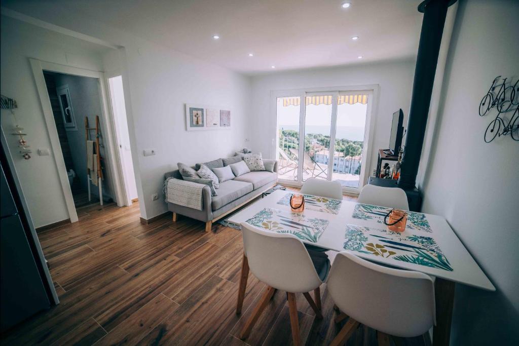 a living room with a table and chairs and a couch at Ka Mahina a Calella de Palafrugell in Calella de Palafrugell