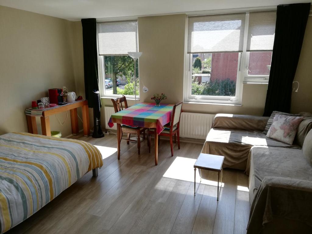 a living room with a table and a couch at Homestay Utrecht in Utrecht