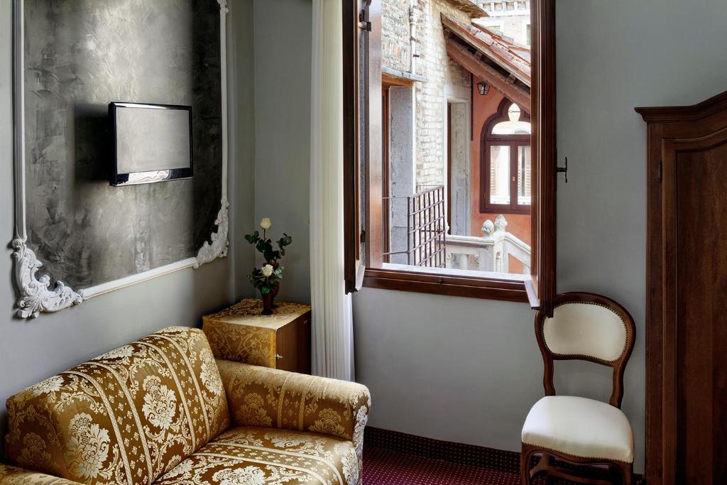 a living room with a couch and a window at Hotel Pausania in Venice