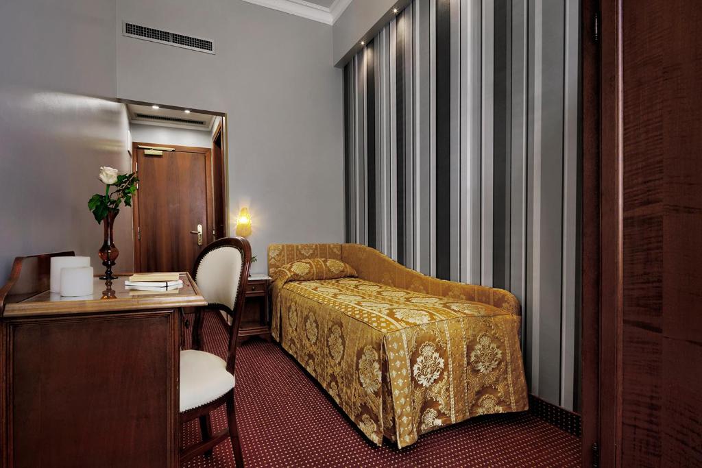 a hotel room with a bed and a desk at Hotel Pausania in Venice