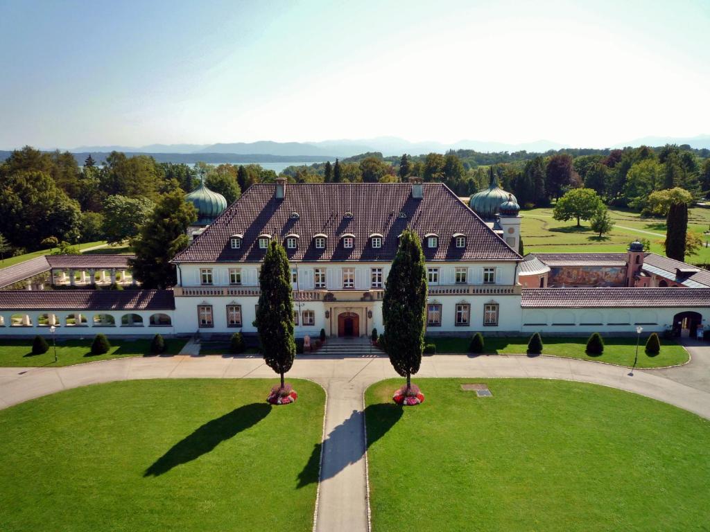 eine Luftansicht eines großen Hauses mit Bäumen davor in der Unterkunft Schloss Höhenried in Bernried