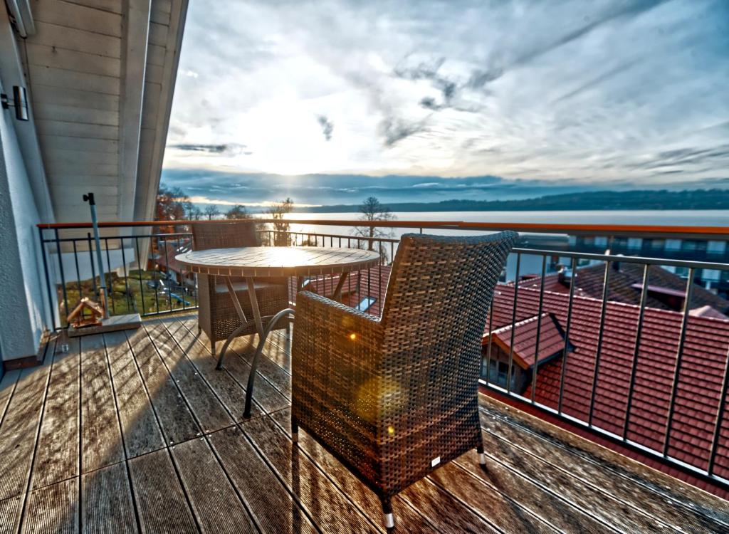 a balcony with a table and chairs on a balcony at Gastl Ferienwohnung und Bootsverleih in Berg am Starnberger See