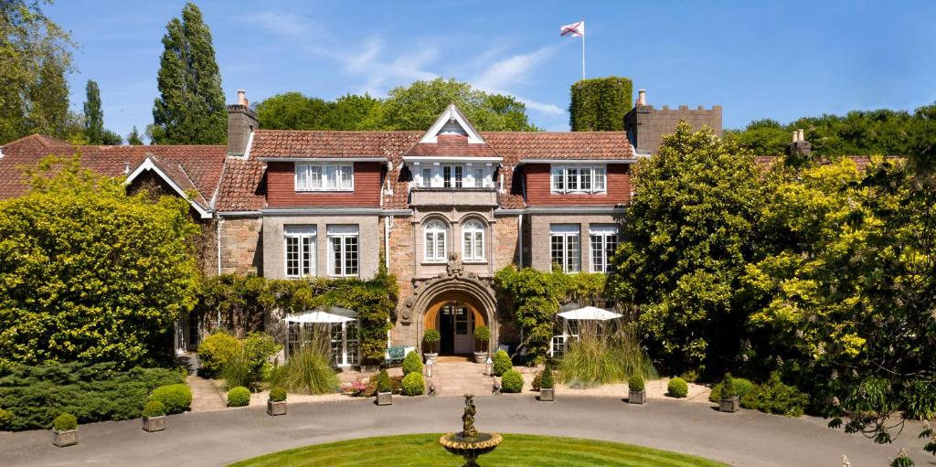 a large house with a clock on the front of it at Longueville Manor in Saint Helier Jersey