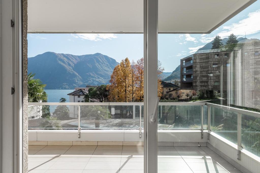 a balcony with a view of a lake and mountains at Maraini 15 by Quokka 360 - bright flat with lake view in Lugano