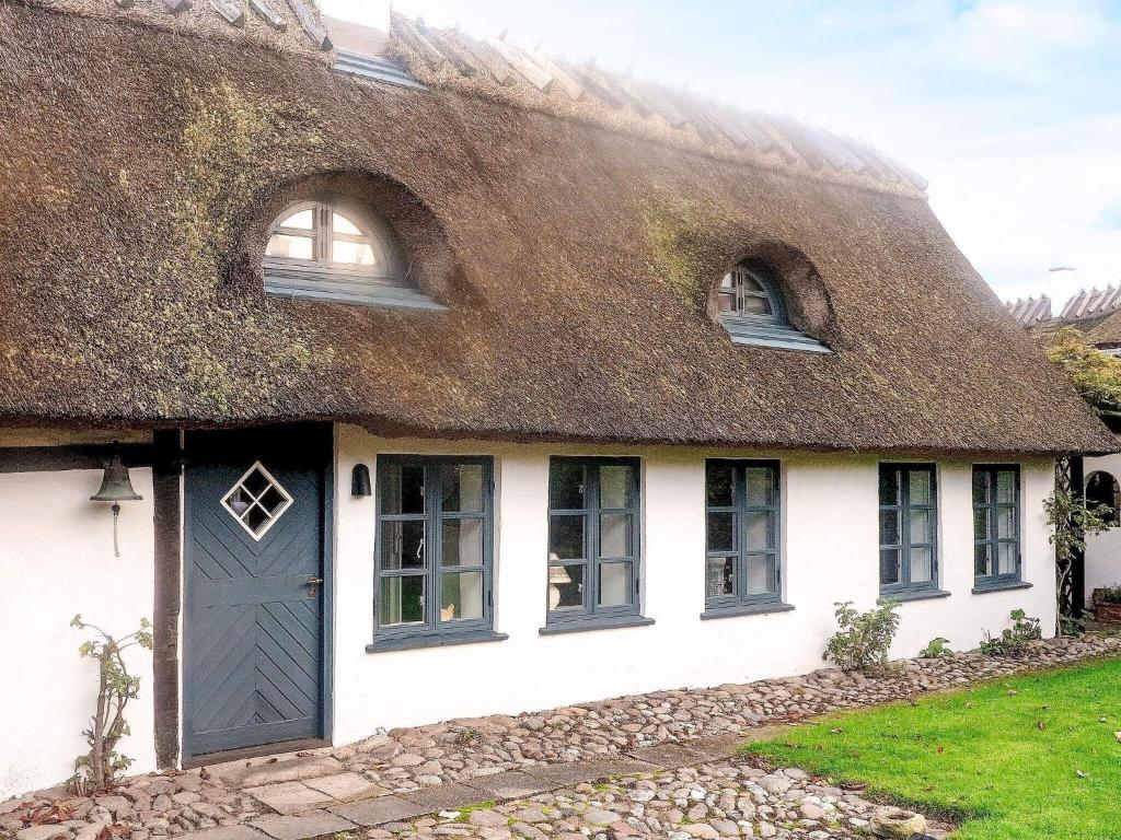 a thatched cottage with a blue door and windows at 2 person holiday home in Gilleleje in Gilleleje