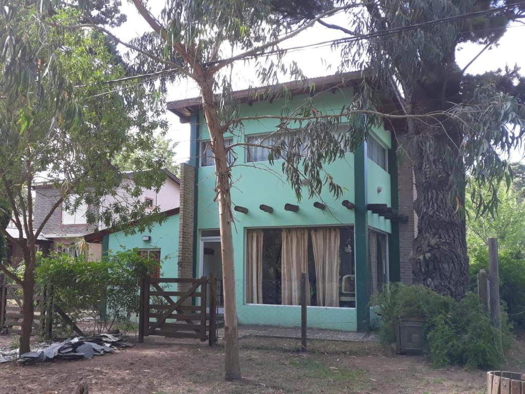 ein blaues Haus mit einem Baum davor in der Unterkunft La casita de Pablo in Santa Teresita