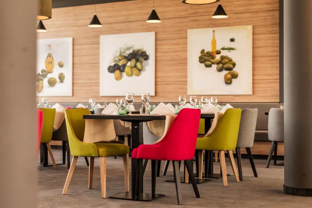 una sala da pranzo con tavolo e sedie colorate di Hotel Olea a Novalja (Novaglia)
