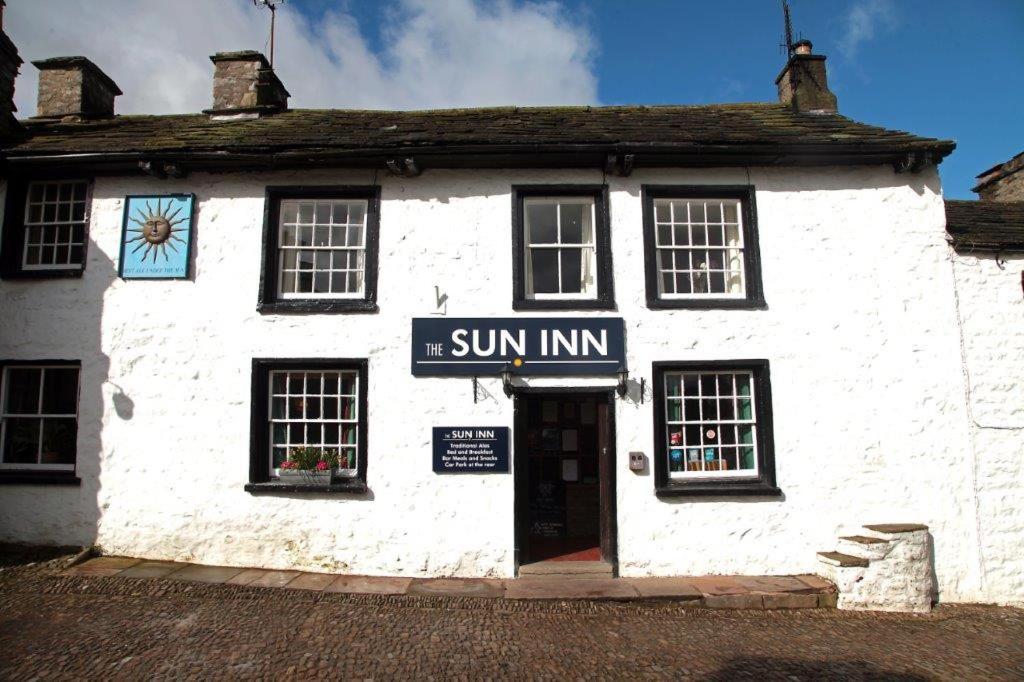 um edifício branco com uma placa de sol em The Sun Inn em Dent