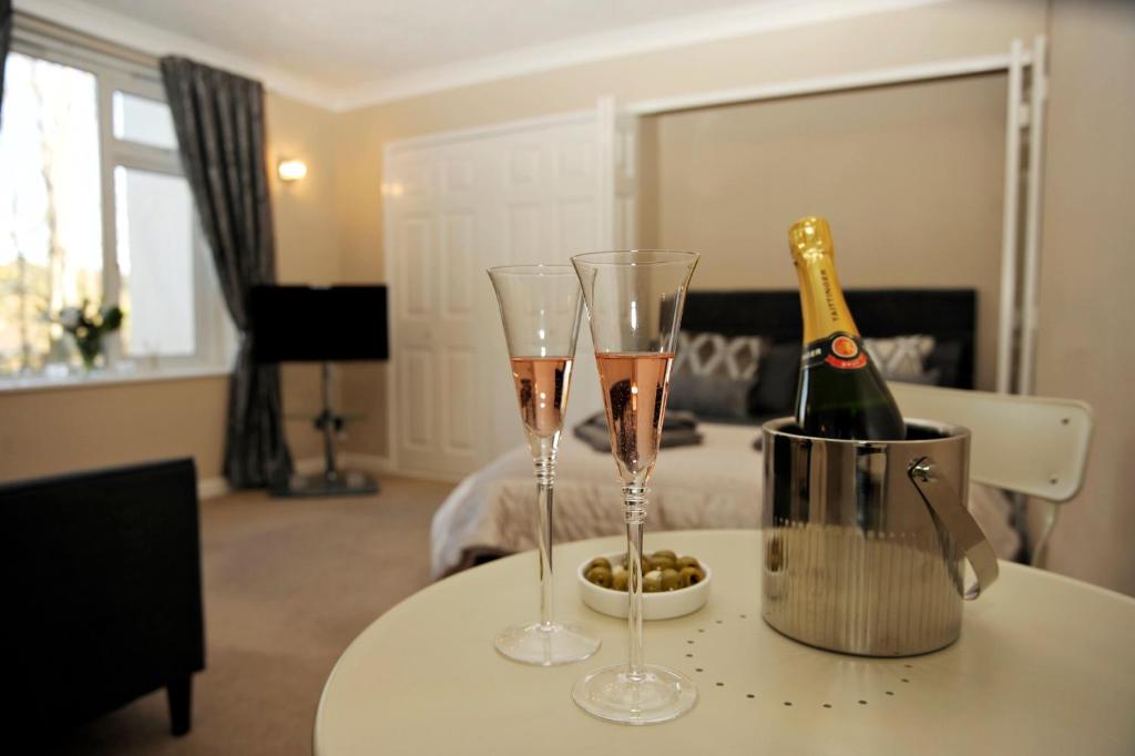 dwa kieliszki szampana na stole z butelką szampana w obiekcie Apartment Bournemouth centre close to beach w Bournemouth