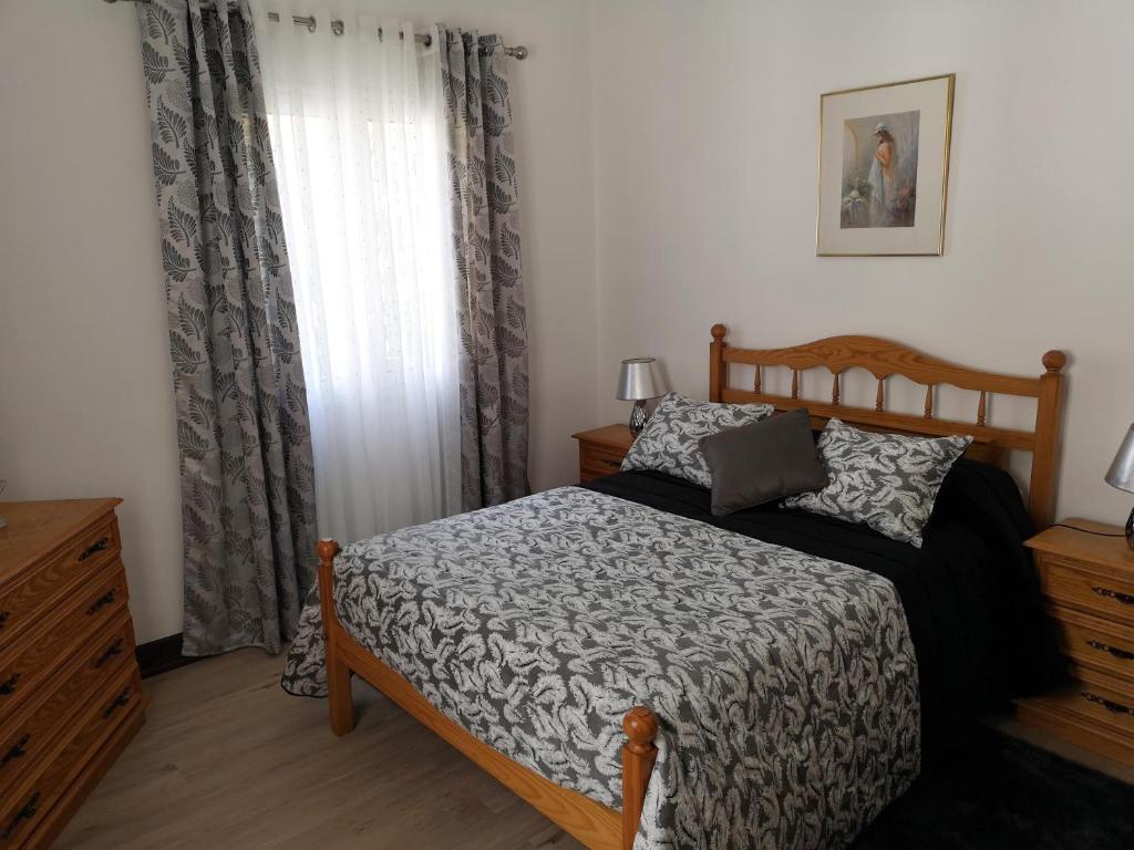 um quarto com uma cama e uma janela com cortinas em VillaHouse em São Vicente