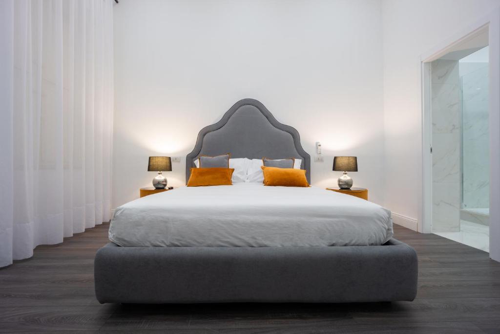 a bedroom with a large bed with orange pillows at Suite Rodinò 24 in Naples