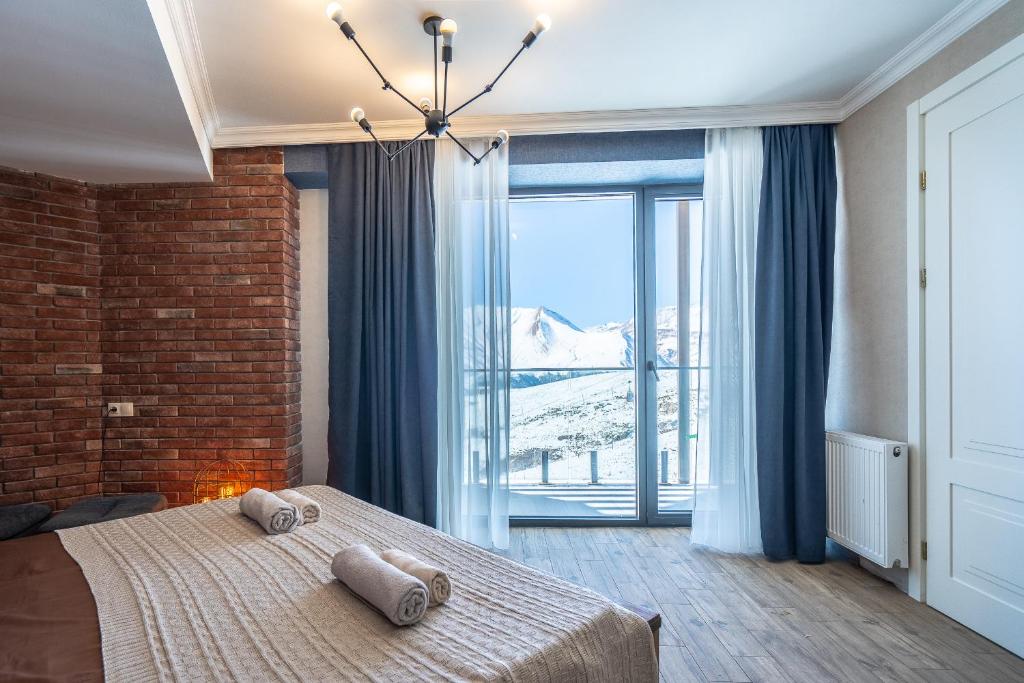 a bedroom with a bed and a large window at Deer Valley - New Gudauri in Gudauri