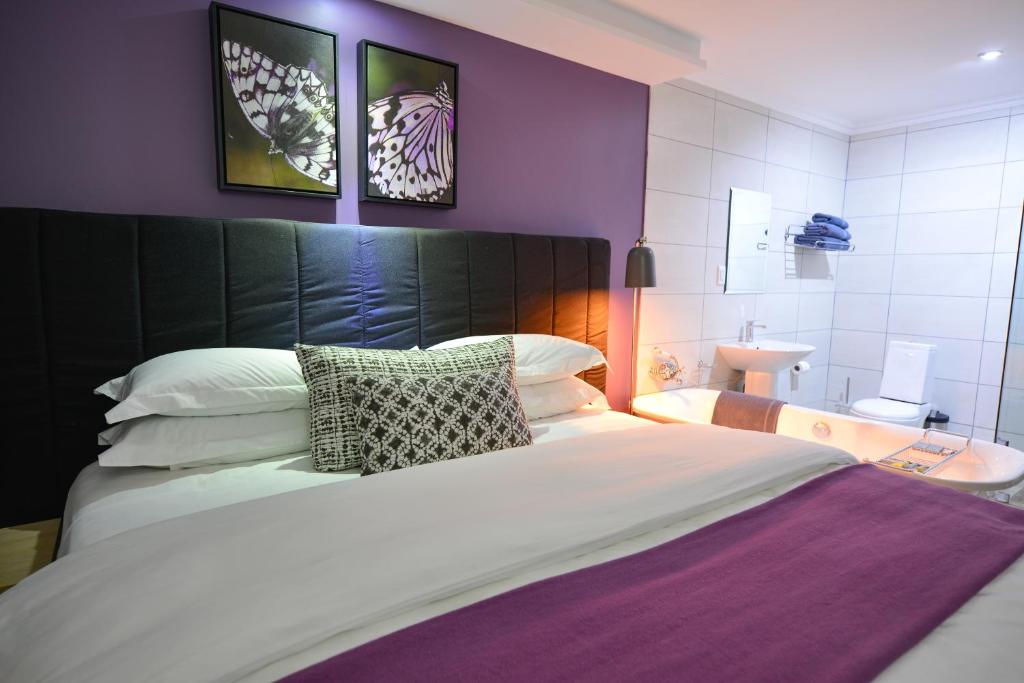 1 dormitorio con 1 cama grande y baño en Serurubele Boutique Hotel, en Bushbuckridge