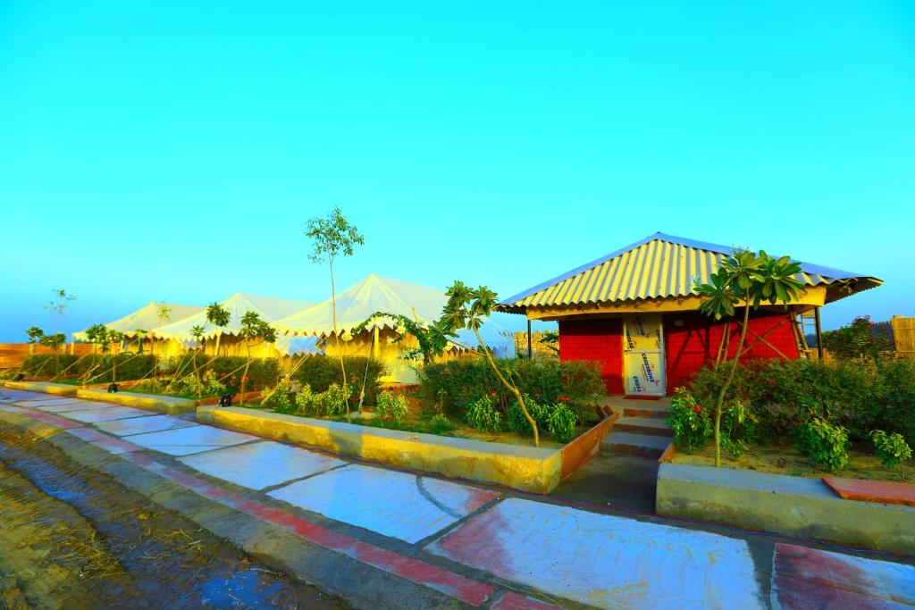 a garden with a red building in the background at Joy Adventures and Resort in Jaipur