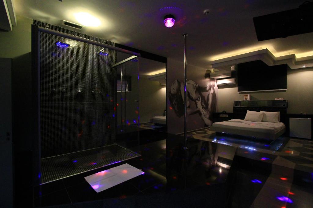a bathroom with a shower and a bed in a room at Movie Inn Motel e Hospedagem in Ribeirão Preto