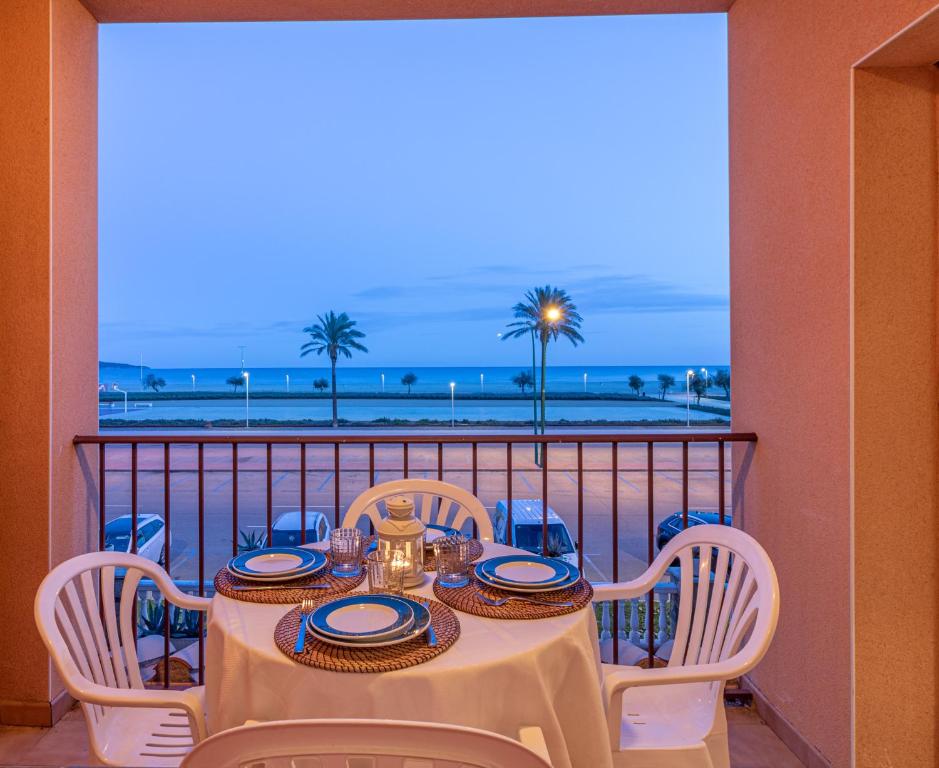 d'une table et de chaises sur un balcon avec vue sur la plage. dans l'établissement Empurialola -Apartamento en primera linea de mar -163, à Empuriabrava