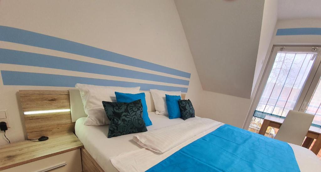 a bedroom with a bed with blue and white pillows at Kempf Apartments in Rust
