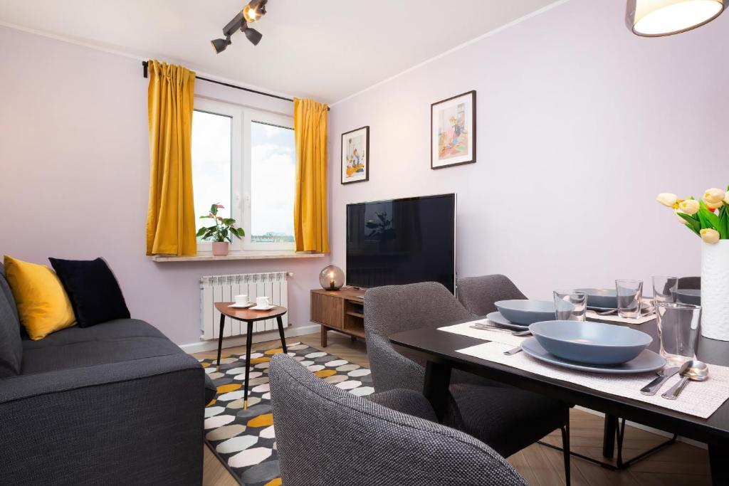 uma sala de estar com um sofá e uma mesa em Apartments Warsaw Nowowiejska by Renters em Varsóvia