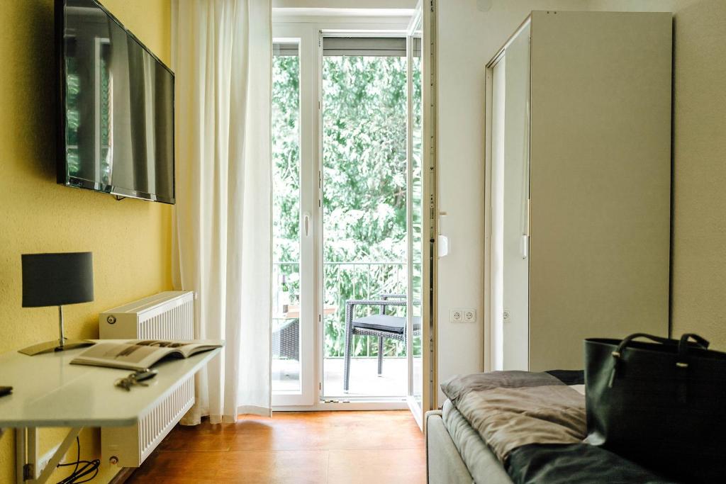 sala de estar con sofá y puerta corredera de cristal en Kleines Zimmer an der TA mit Balkon (Nr.3), en Hameln