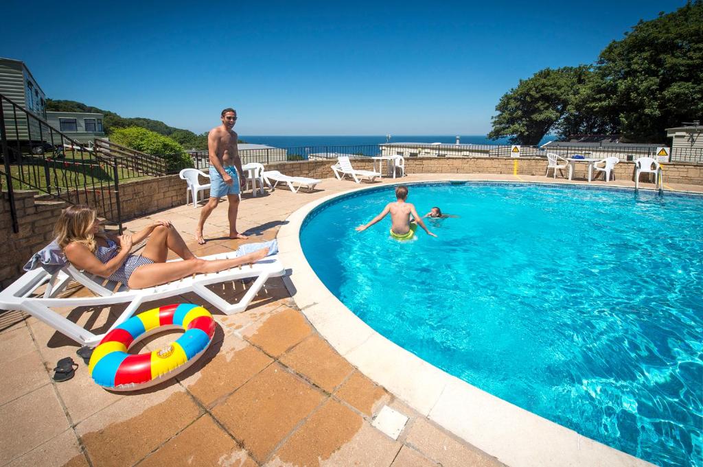 un grupo de personas sentadas en una piscina en Sandaway Holiday Park en Combe Martin