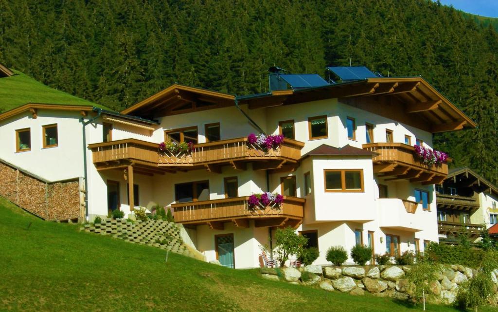 un gran edificio blanco con balcones en una colina en Haus Ausblick en Tux