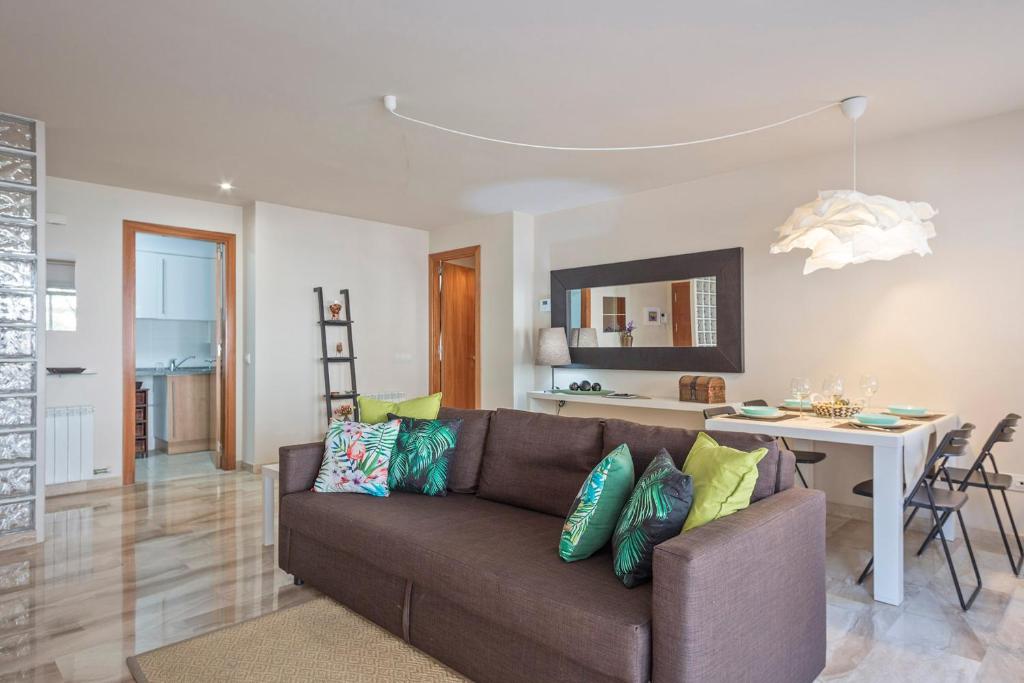 sala de estar con sofá marrón y mesa en Habitat Apartments Duna en Mataró