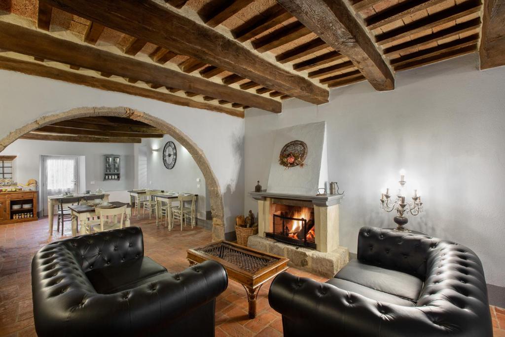 salon z 2 skórzanymi krzesłami i kominkiem w obiekcie B&B Gli Archi w mieście Abbadia San Salvatore