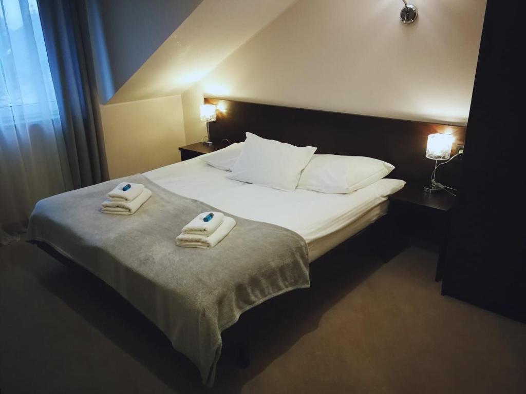 1 dormitorio con 1 cama con 2 toallas en Volter, en Gdansk