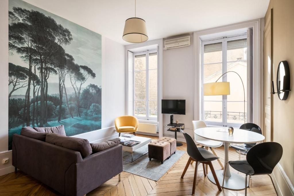 a living room with a couch and a table at Honorê - Suite Barre in Lyon