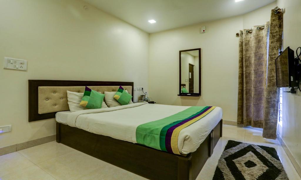 ein Schlafzimmer mit einem großen Bett und einem Spiegel in der Unterkunft Hotel Royal Elite Madurai in Madurai