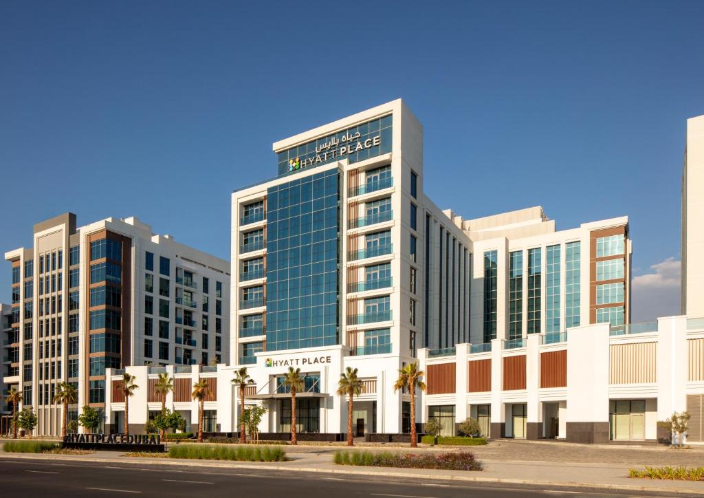 a rendering of a building with palm trees in front at Hyatt Place Dubai Jumeirah Residences in Dubai