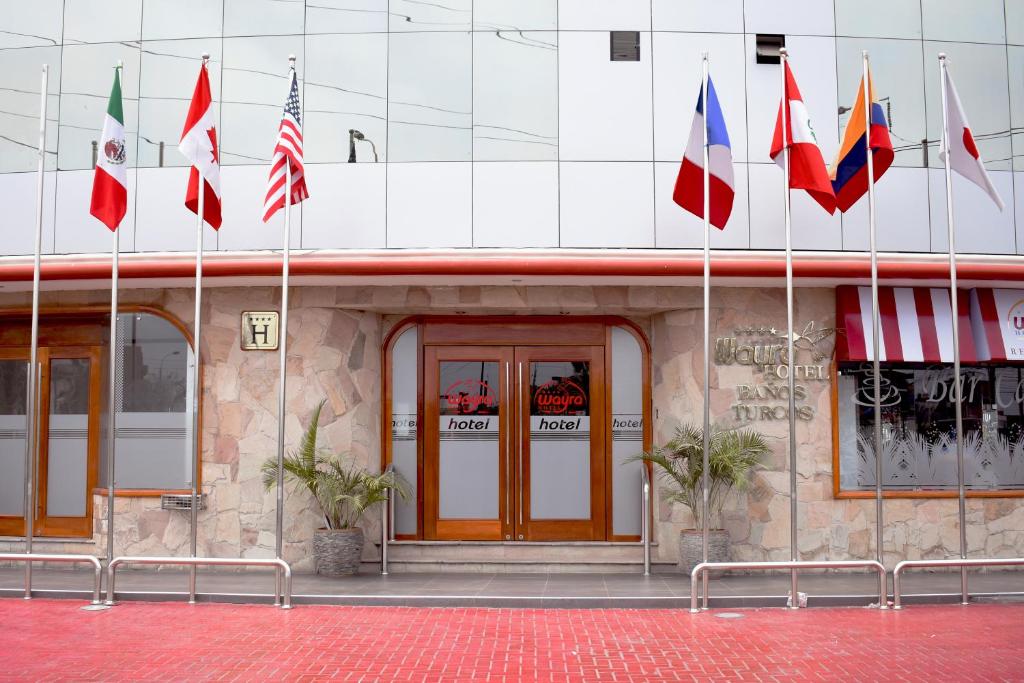 un edificio con diferentes banderas delante de él en Hotel Wayra, en Lima