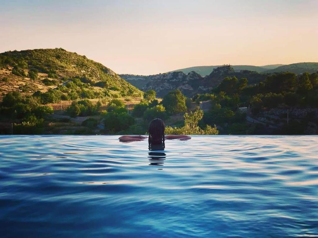 una persona nadando en el agua en un lago en Dream House, en Noto