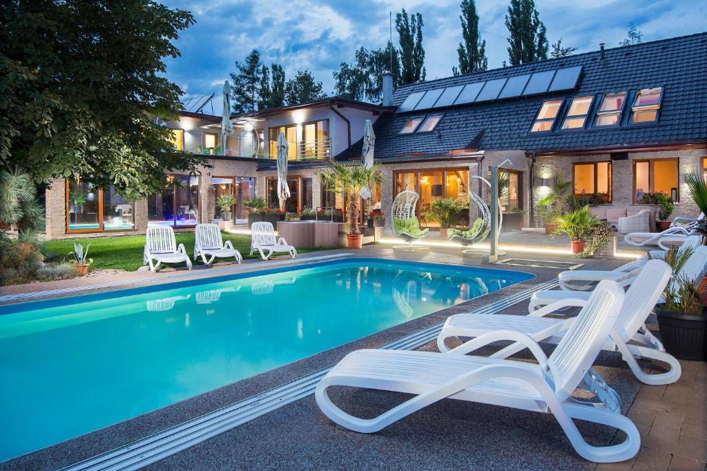 una casa con piscina con sedie a sdraio e una casa di Aqua & Wellness resort Alzbeta a Liptovský Mikuláš