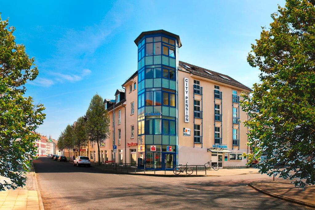 un edificio alto al lado de una calle en City-Pension Dessau-Roßlau, en Dessau