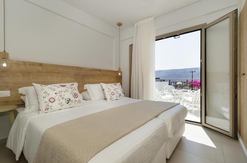 1 dormitorio con 1 cama grande y balcón en Minoa Apartments, en Amoudara Herakliou